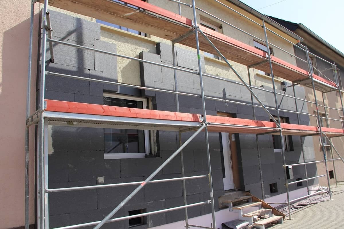Haus mit Gerüst, dass gerade gedämmt wird