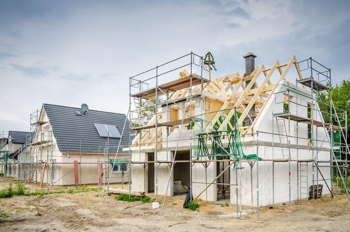 Bild1 - Beim Hausbau gibt es viel zu tun. Eigenleistung spart Geld Ein Rohbau mit Gerüst. Der Bauherr erledigt viele Arbeiten in Eigenleistung. Durch die Muskelhypothek will er so Geld sparen.